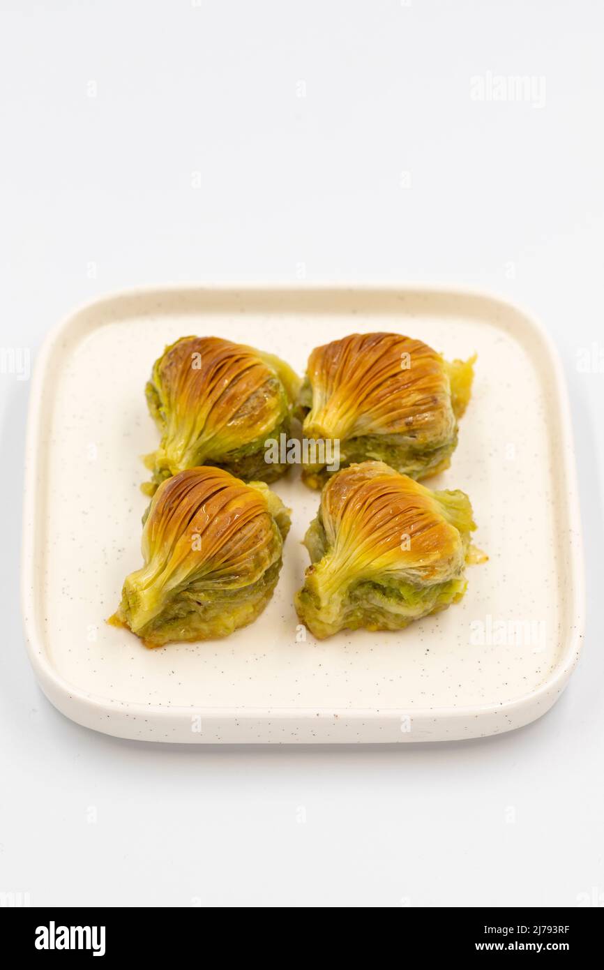 Baklava di muschio. Pistacchio baklava isolato su sfondo bianco. Prelibatezze della cucina mediterranea. Primo piano. Nome locale midye baklava Foto Stock