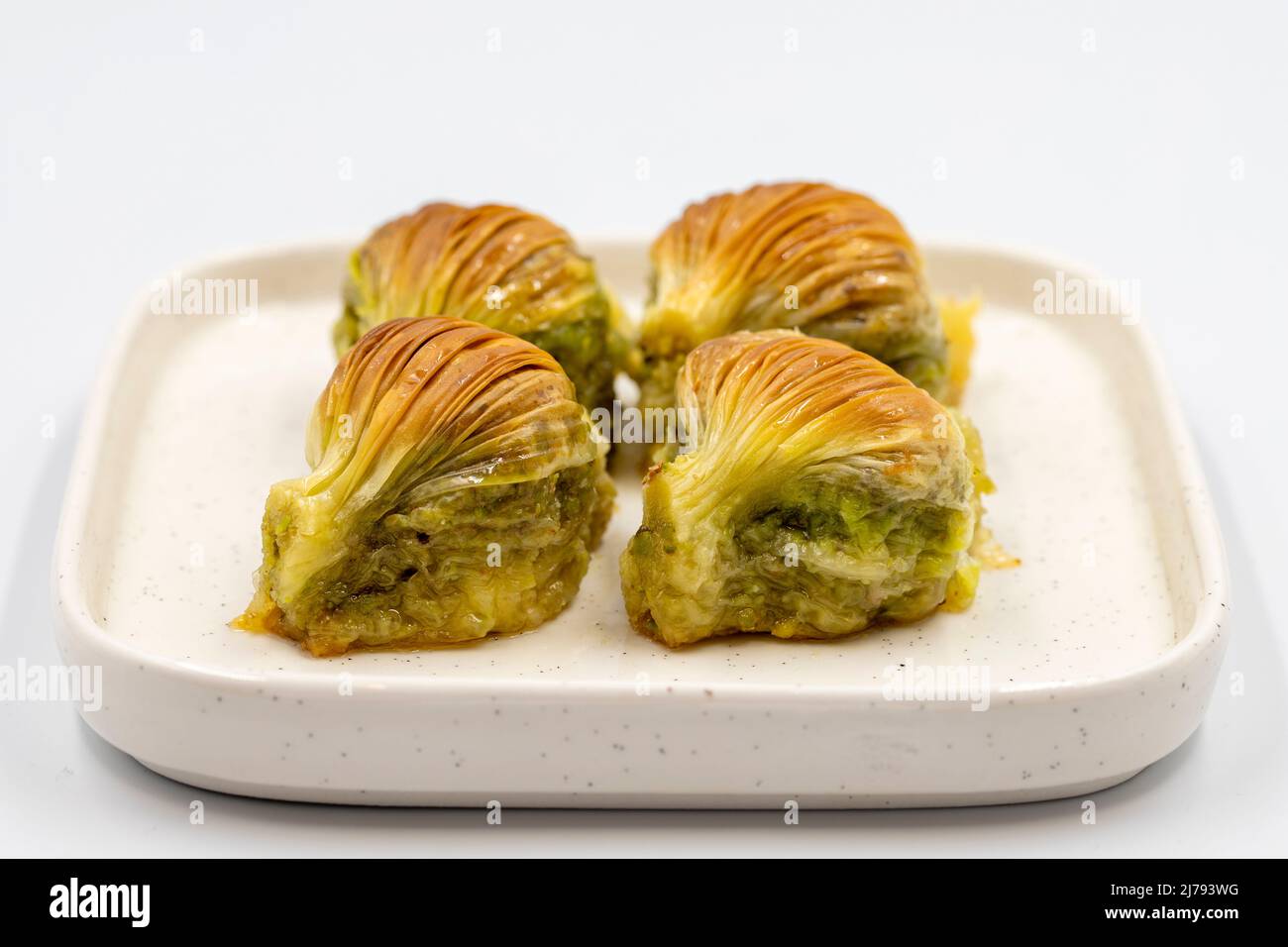 Baklava di muschio. Pistacchio baklava isolato su sfondo bianco. Prelibatezze della cucina mediterranea. Primo piano. Nome locale midye baklava Foto Stock