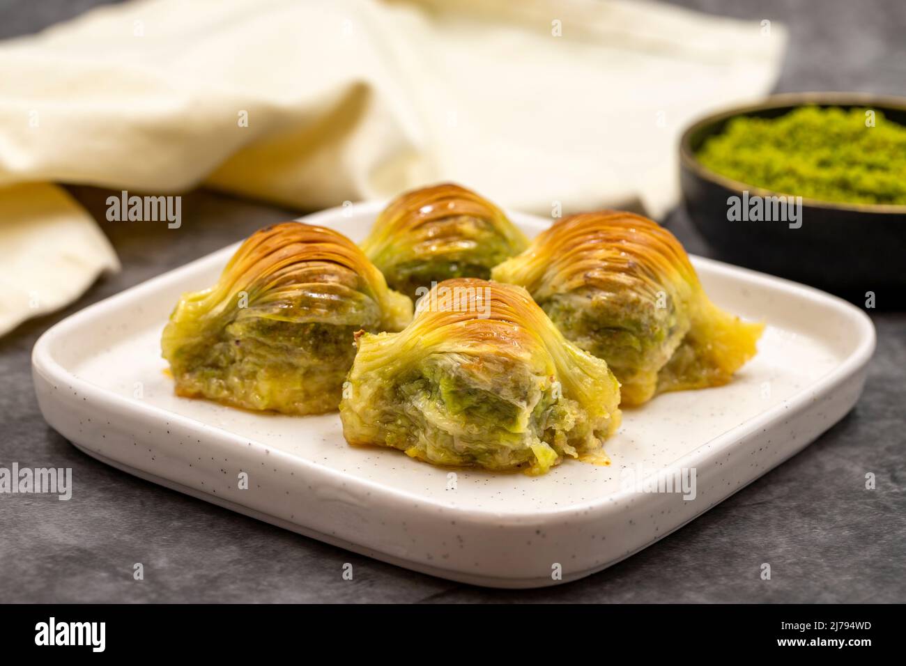 Baklava di muschio. Pistacchio baklava su sfondo scuro. Prelibatezze della cucina mediterranea. Primo piano. Nome locale midye baklava Foto Stock