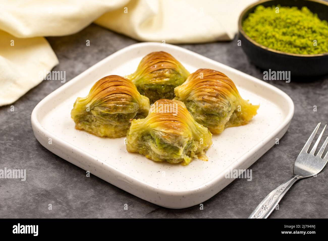 Baklava di muschio. Pistacchio baklava su sfondo scuro. Prelibatezze della cucina mediterranea. Primo piano. Nome locale midye baklava Foto Stock