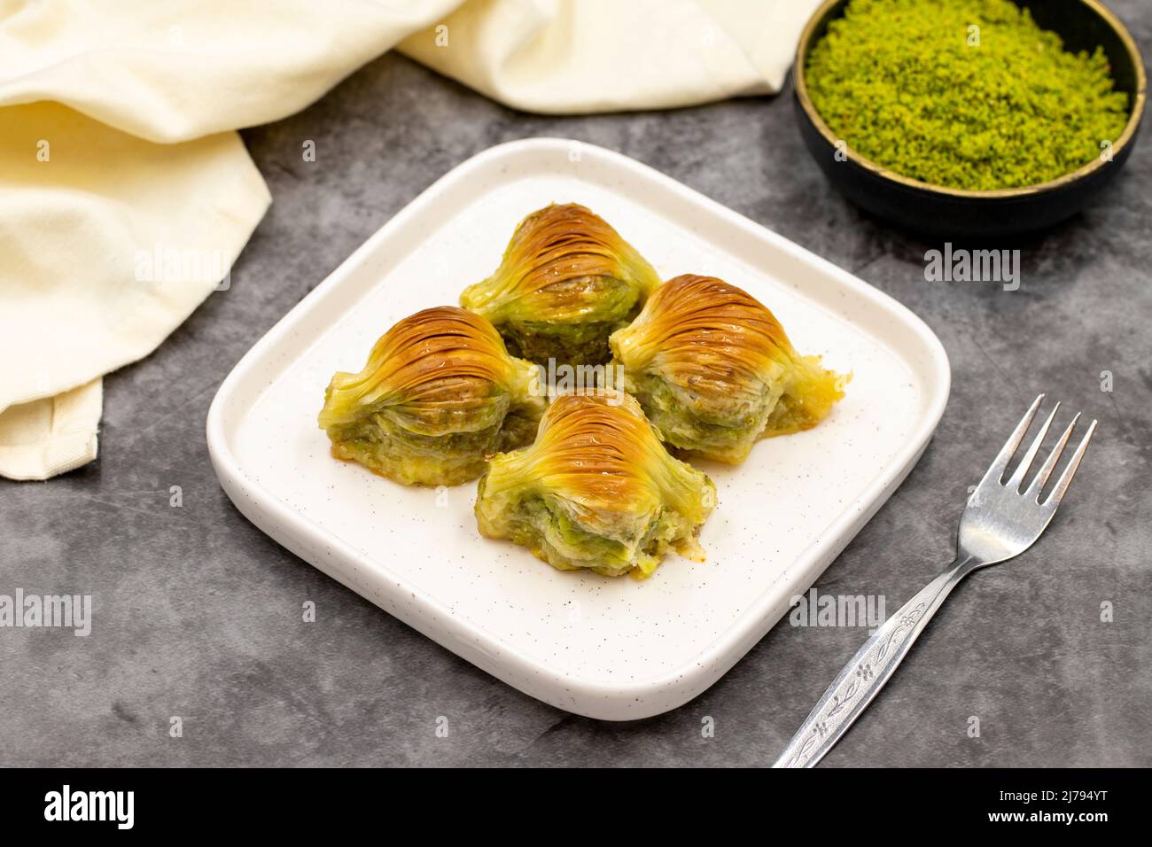 Baklava di muschio. Pistacchio baklava su sfondo scuro. Prelibatezze della cucina mediterranea. Primo piano. Nome locale midye baklava Foto Stock