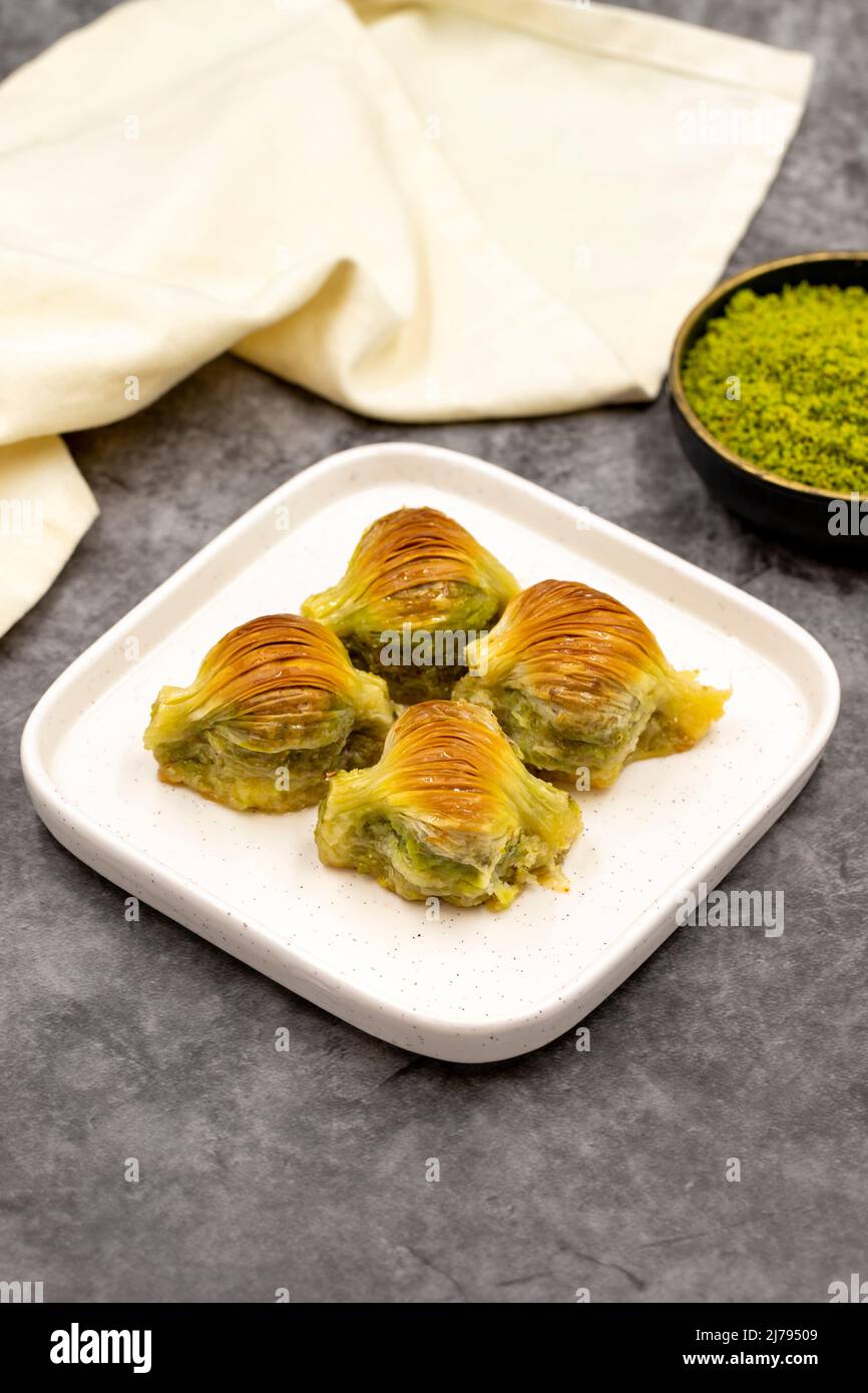 Baklava di muschio. Pistacchio baklava su sfondo scuro. Prelibatezze della cucina mediterranea. Primo piano. Nome locale midye baklava Foto Stock