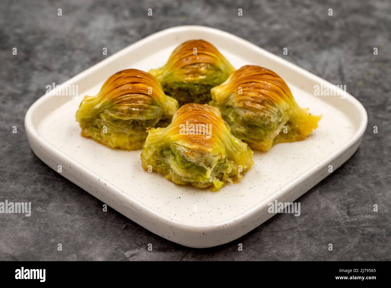 Baklava di muschio. Pistacchio baklava su sfondo scuro. Prelibatezze della cucina mediterranea. Primo piano. Nome locale midye baklava Foto Stock