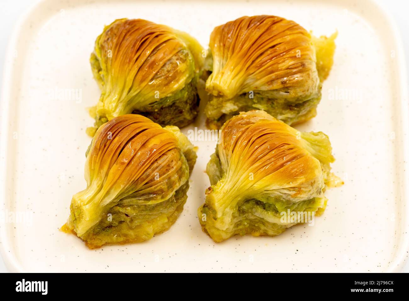 Baklava di muschio. Pistacchio baklava isolato su sfondo bianco. Prelibatezze della cucina mediterranea. Primo piano. Nome locale midye baklava Foto Stock
