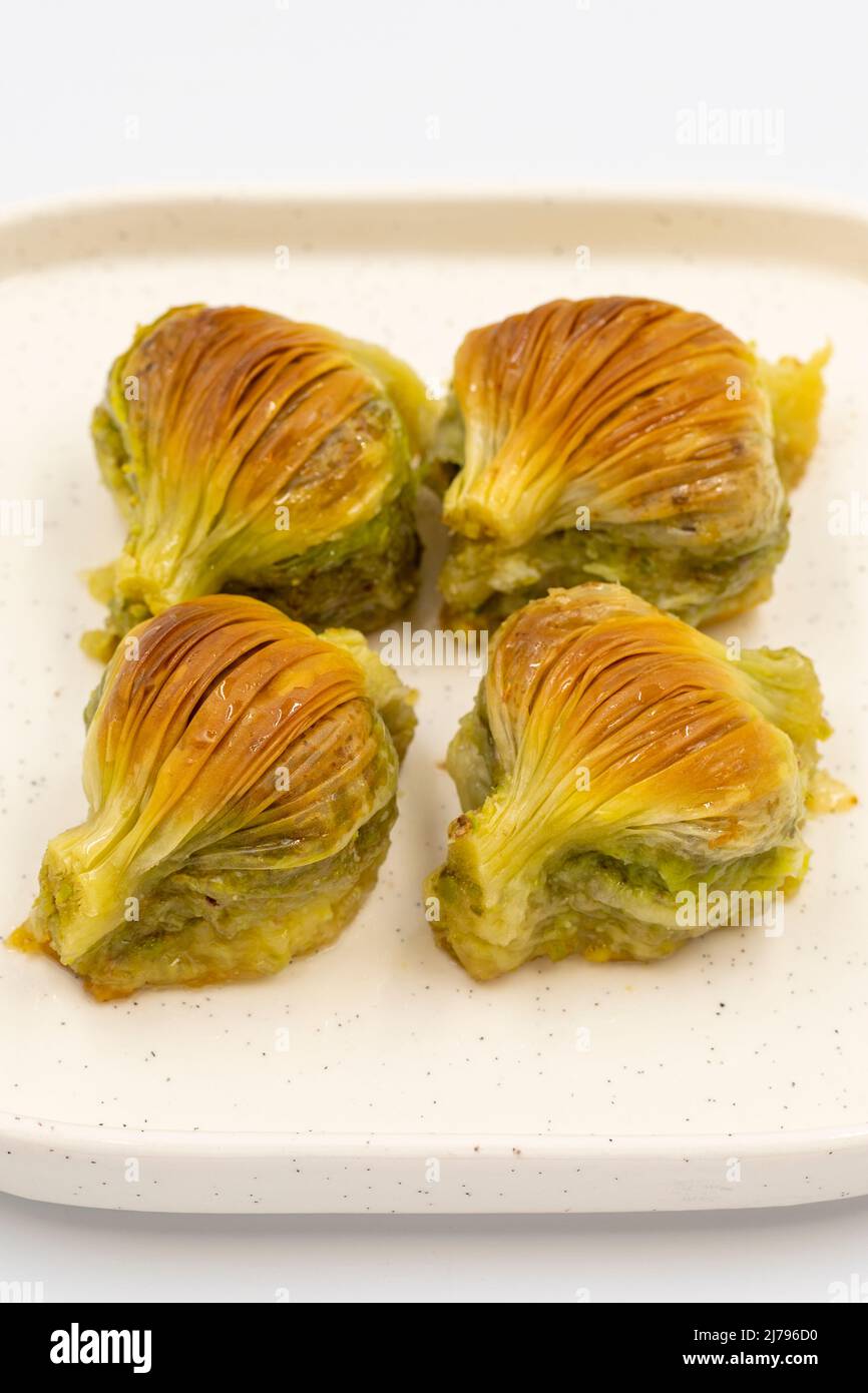 Baklava di muschio. Pistacchio baklava isolato su sfondo bianco. Prelibatezze della cucina mediterranea. Primo piano. Nome locale midye baklava Foto Stock