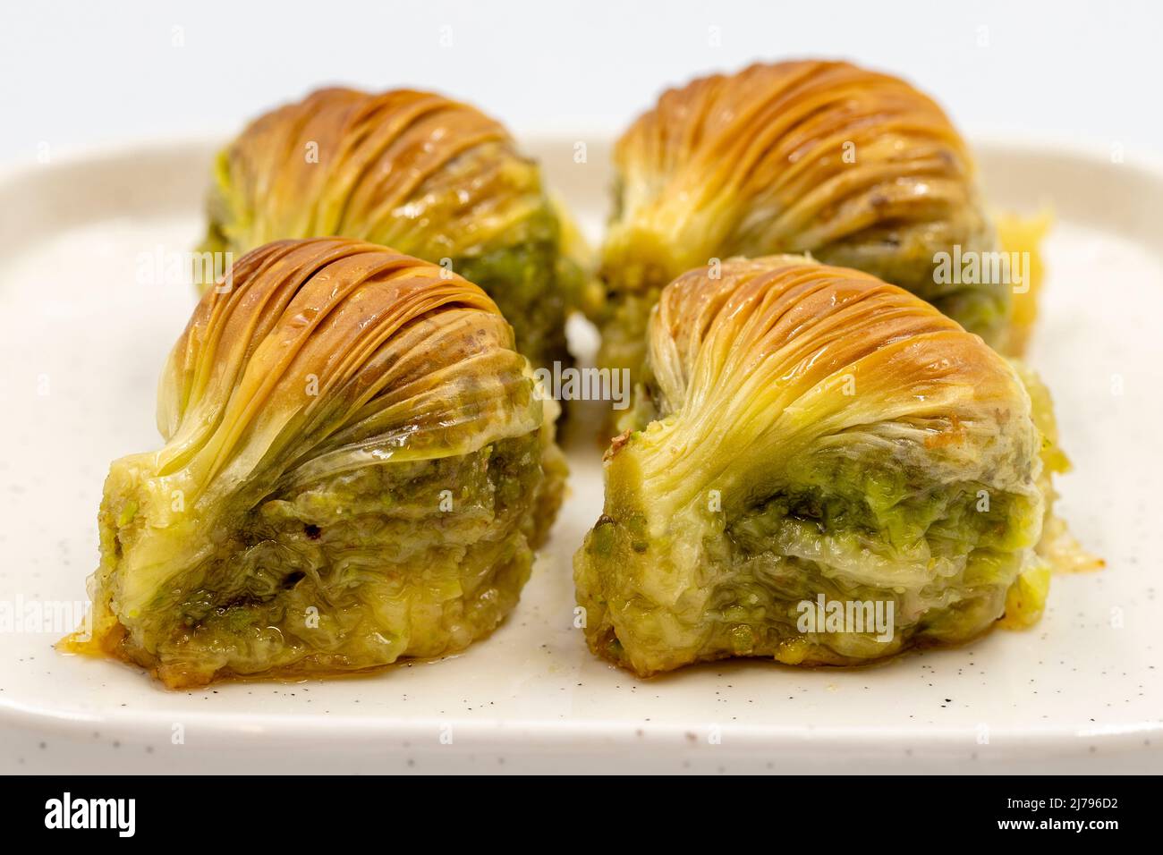 Baklava di muschio. Pistacchio baklava isolato su sfondo bianco. Prelibatezze della cucina mediterranea. Primo piano. Nome locale midye baklava Foto Stock