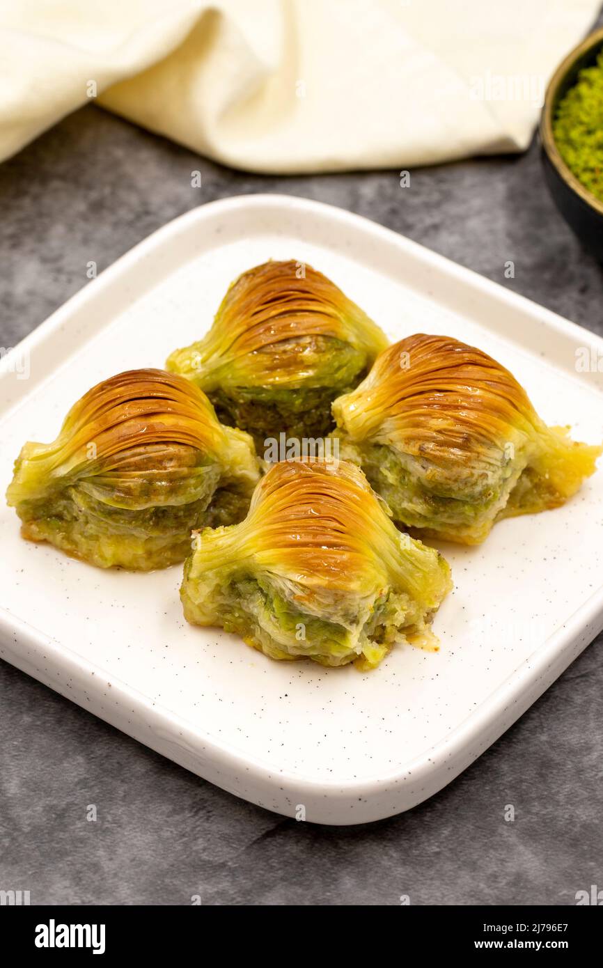 Baklava di muschio. Pistacchio baklava su sfondo scuro. Prelibatezze della cucina mediterranea. Primo piano. Nome locale midye baklava Foto Stock