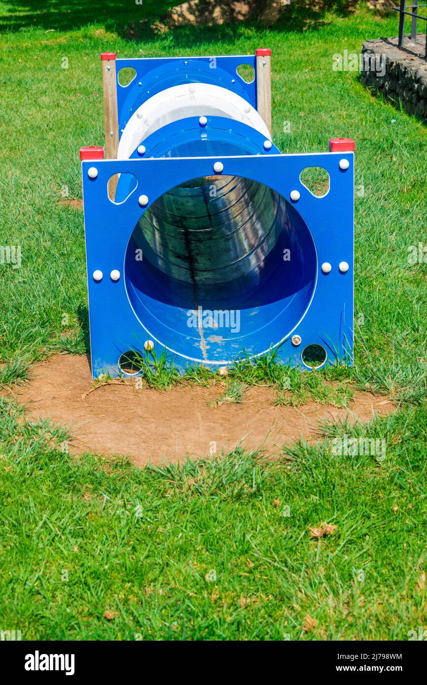 Circuito di agility tunnel blu per cani con erba e giornata di sole Foto Stock