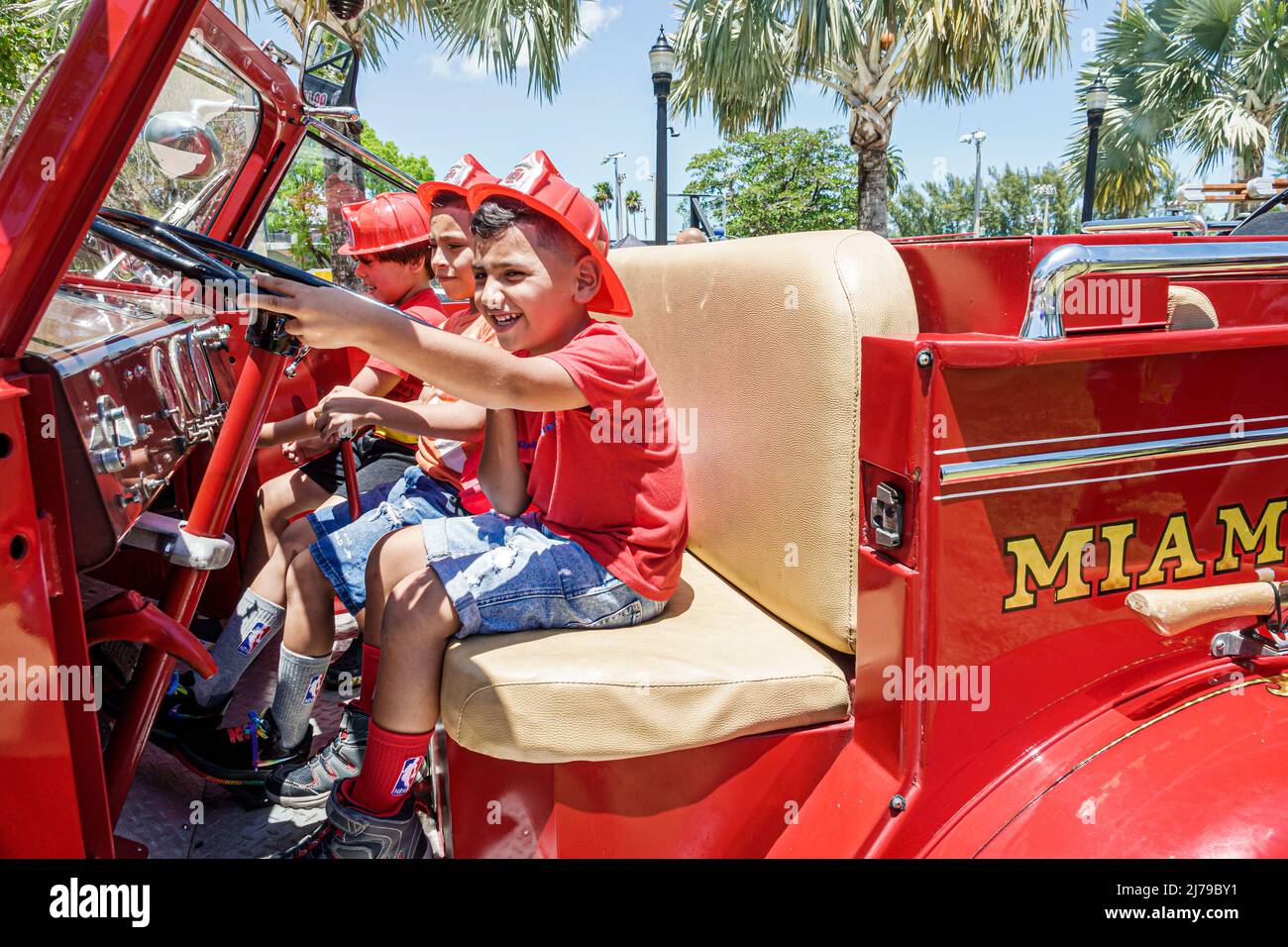 Miami Beach Florida Annual Miami Beach Police Block Party Family Free Event Flamingo Park Fire Engine Ispanic ragazzo ragazzi ragazza fratelli sedile conducente Foto Stock