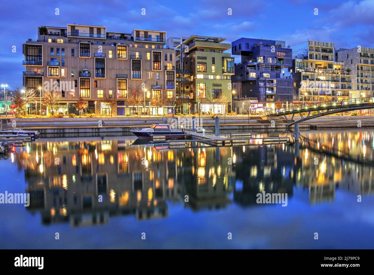 Scena notturna con moderni edifici residenziali su un piccolo canale nel quartiere post-moderno di la Confluence a Lione, Francia Foto Stock