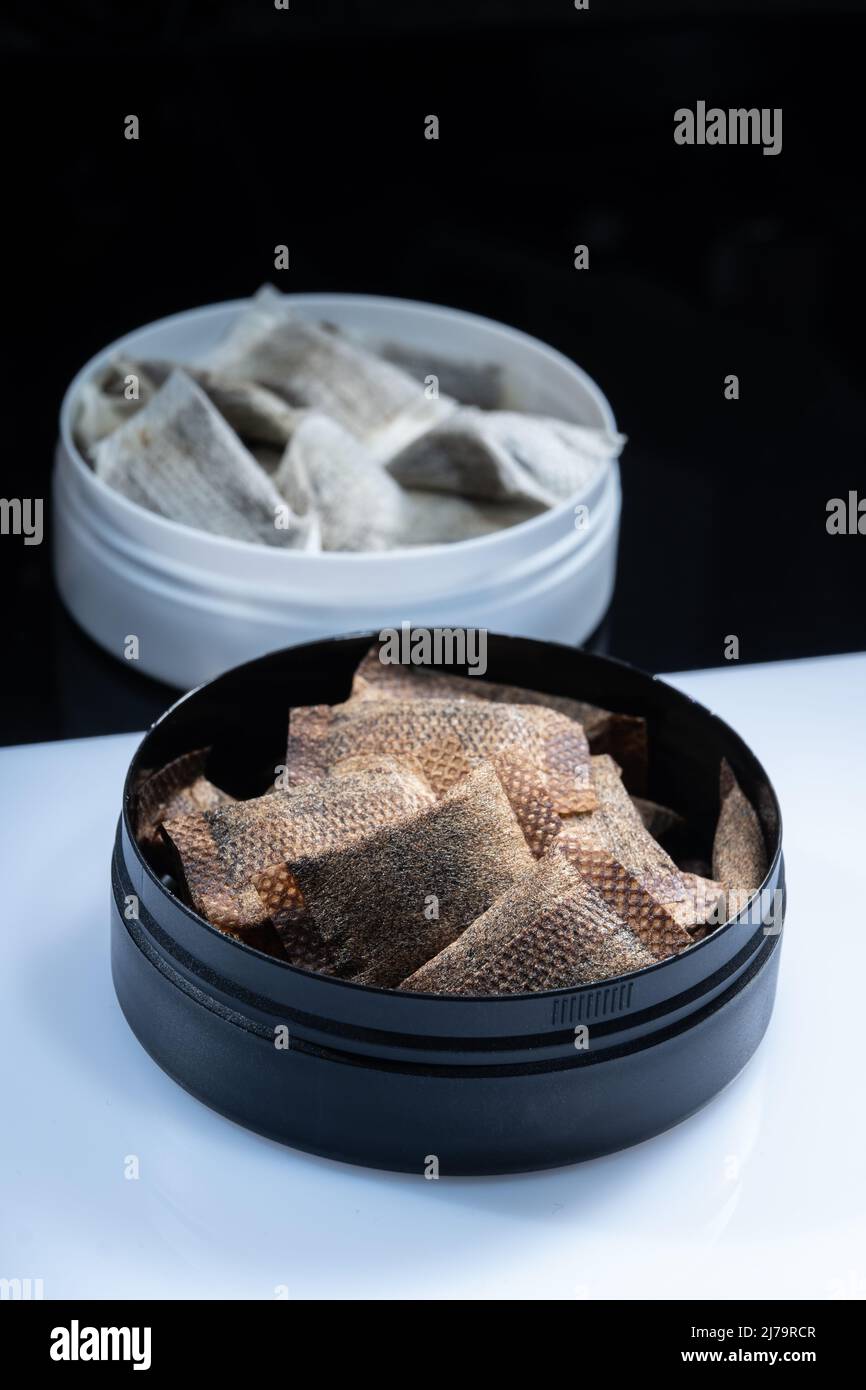 Primo piano di due prodotti svedesi del tabacco senza fumo. Lattine snus con fiocco di parte bianca e regolare Foto Stock
