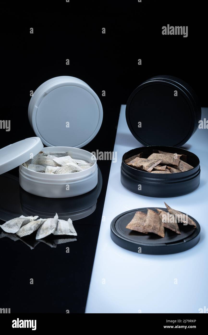 Primo piano di due prodotti svedesi del tabacco senza fumo. Lattine snus con fiocco di parte bianca e regolare Foto Stock