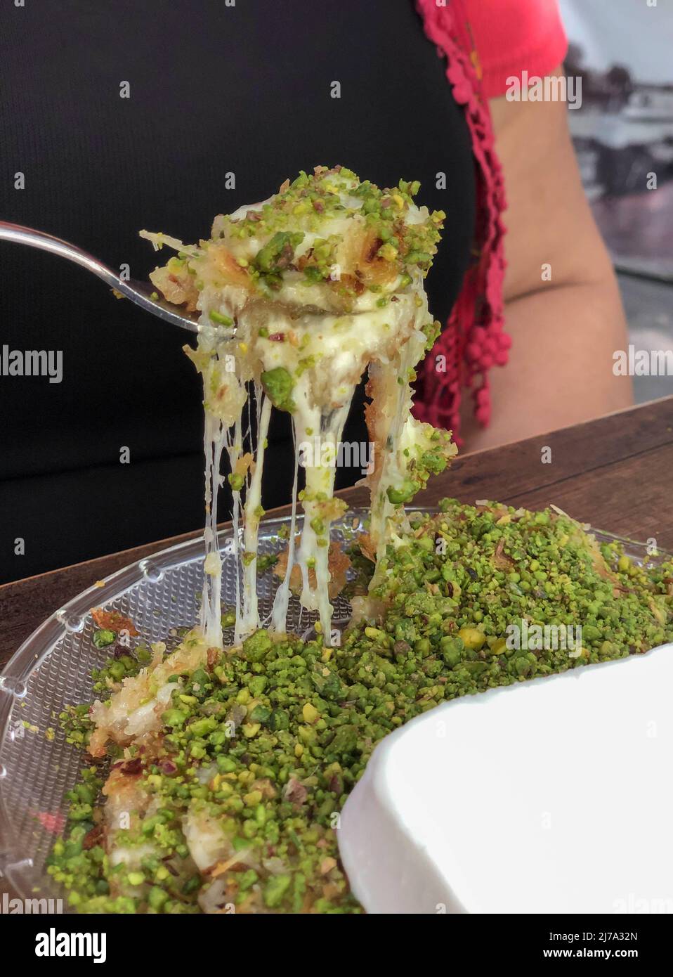 Kunefe che è tradizionale dessert turco con formaggio all'interno servito con pistacchio Foto Stock