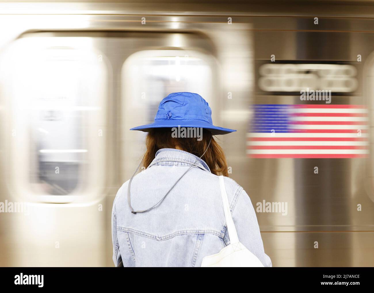 Una donna vestita per la pioggia e il tempo incessante aspetta mentre una macchina della metropolitana arriva a New York City sabato 7 2022 maggio. Foto di John Angelillo/UPI Foto Stock