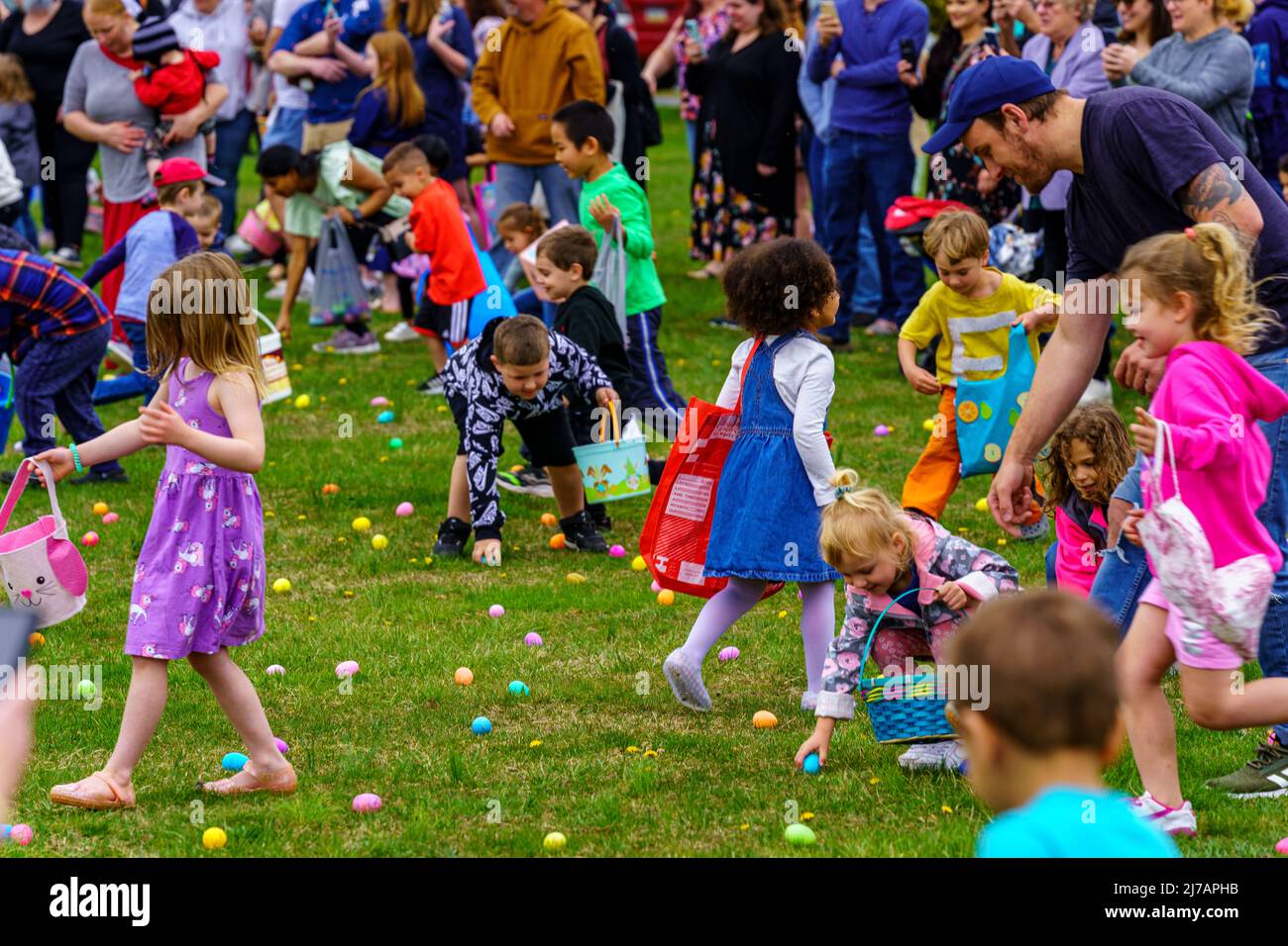 Terre Hill, PA, USA - 16 aprile 2022: I bambini corrono per le uova di Pasqua durante una caccia che sono sparse in un evento locale della comunità primaverile in un ambiente rurale Foto Stock