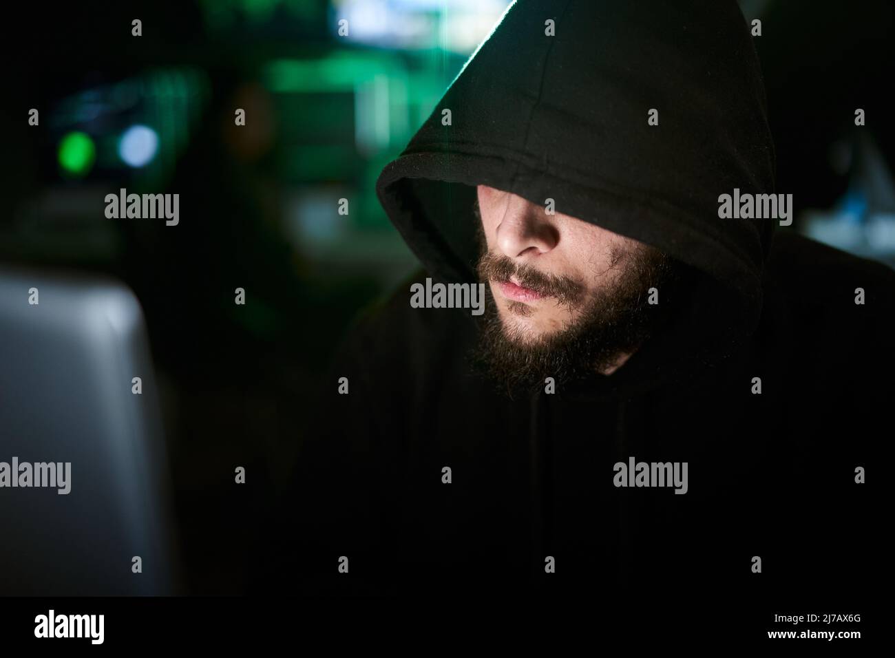 Hacker del team criminale che utilizza il computer per organizzare un attacco di massiccia violazione dei dati contro i server governativi e delle grandi aziende. La camera oscura circondavano i computer Foto Stock