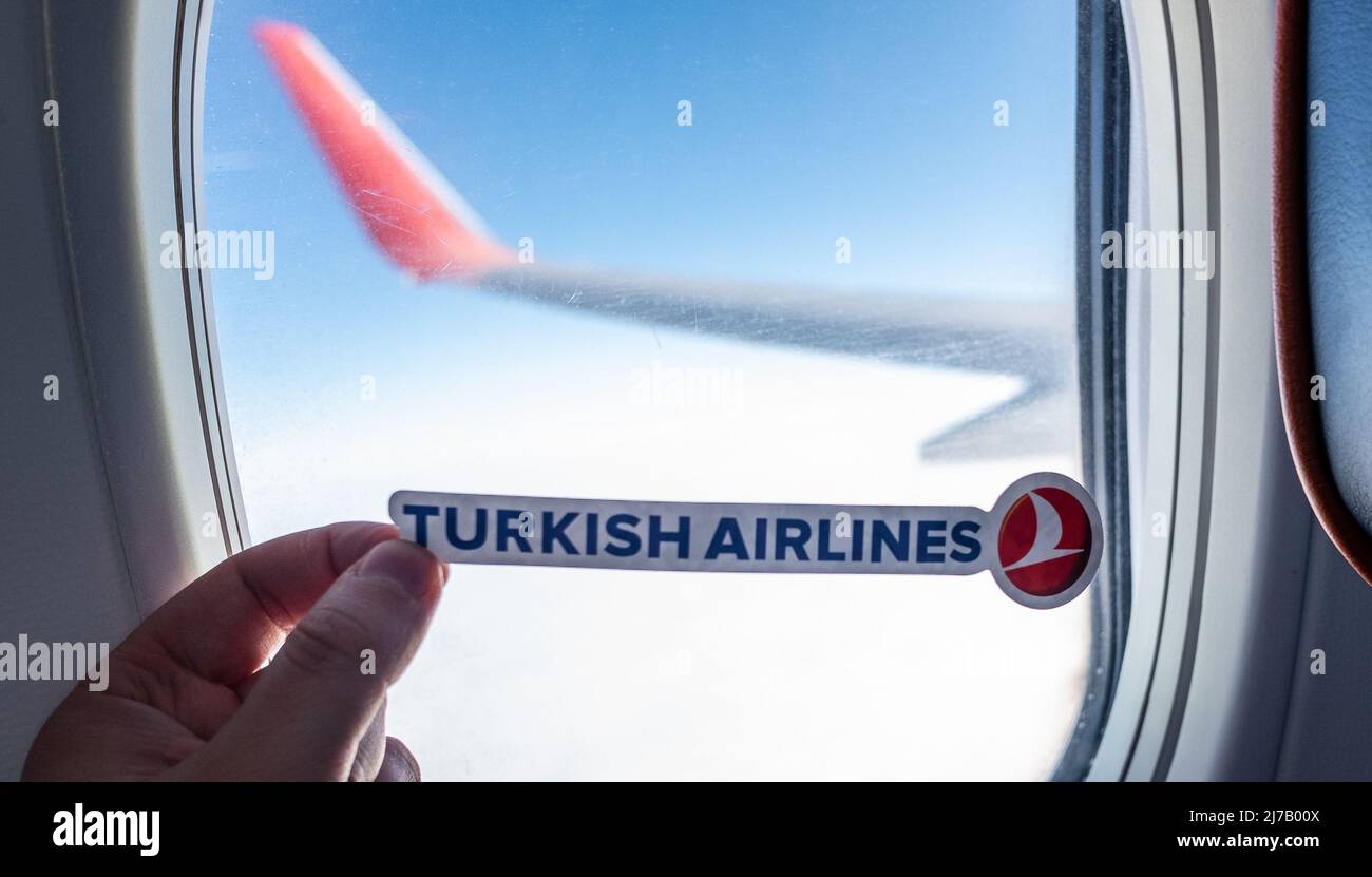 6 dicembre 2021, Istanbul, Turchia. L'emblema della compagnia aerea Turkish Airlines sullo sfondo della finestra dell'aeromobile. Foto Stock