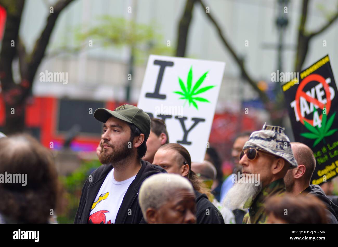 Gli attivisti hanno visto con i cartelli durante la sfilata annuale di Cannabis attraverso Broadway a New York il 4 maggio 2019. Foto Stock