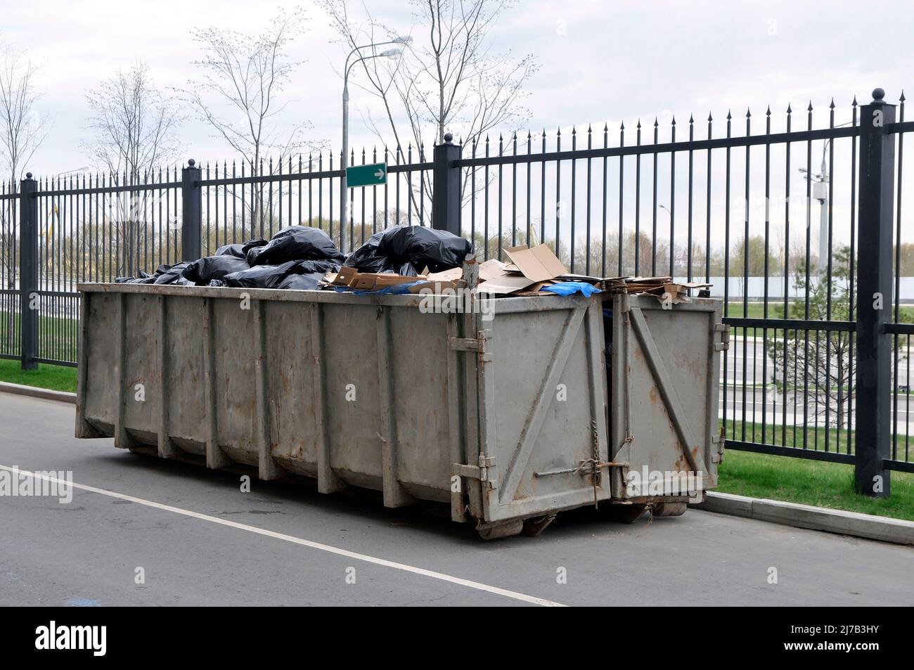 Contenitore in metallo con rifiuti non ordinati. Raccolta, stoccaggio e rimozione dei rifiuti solidi urbani. Foto Stock