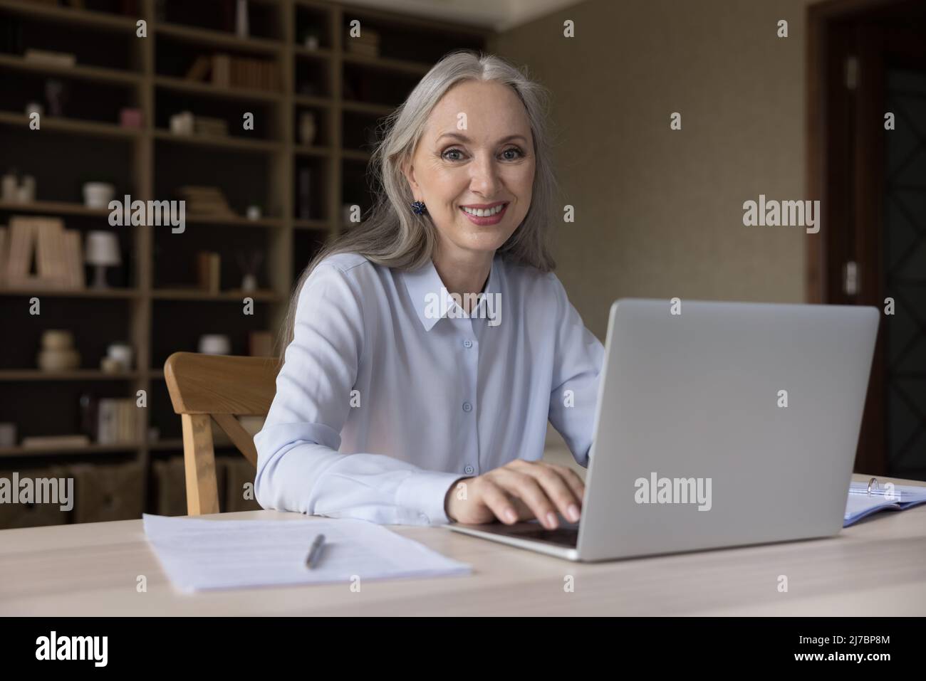 Donna insegnante in linea anziana felice che usa il computer portatile Foto Stock