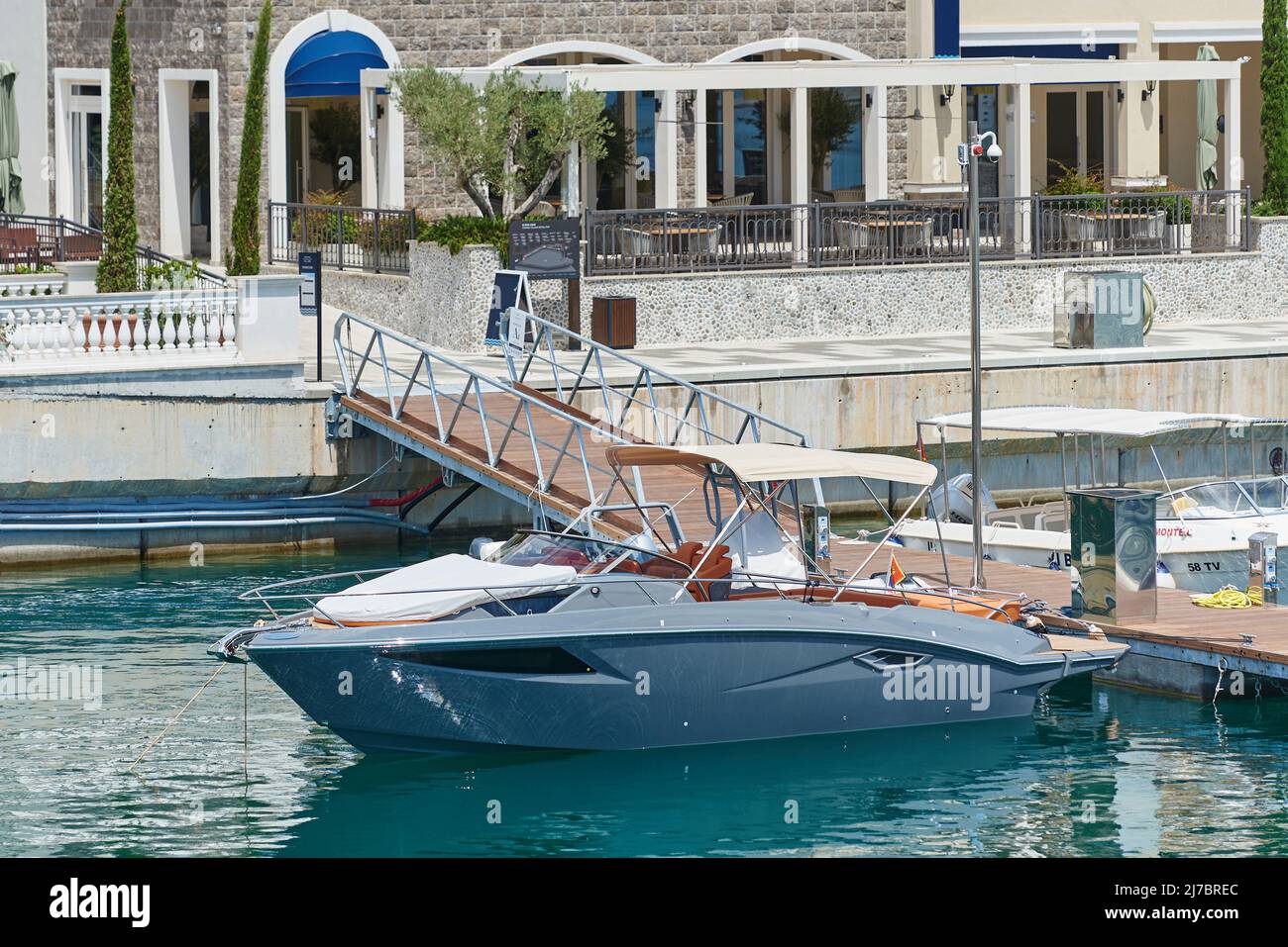 Piccolo yacht di colore grigio ormeggiato al molo Foto Stock