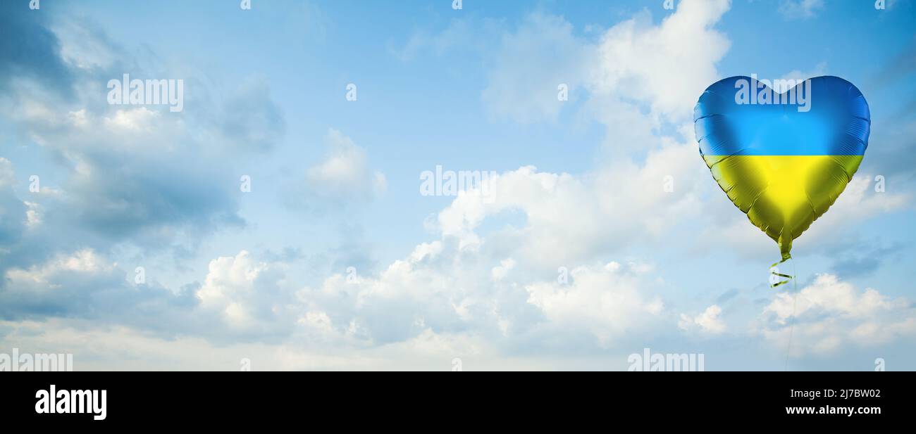 Palloncino cardiaco con bandiera Ucraina sullo sfondo delle nuvole di cielo. Amore Ucraina concetto Foto Stock