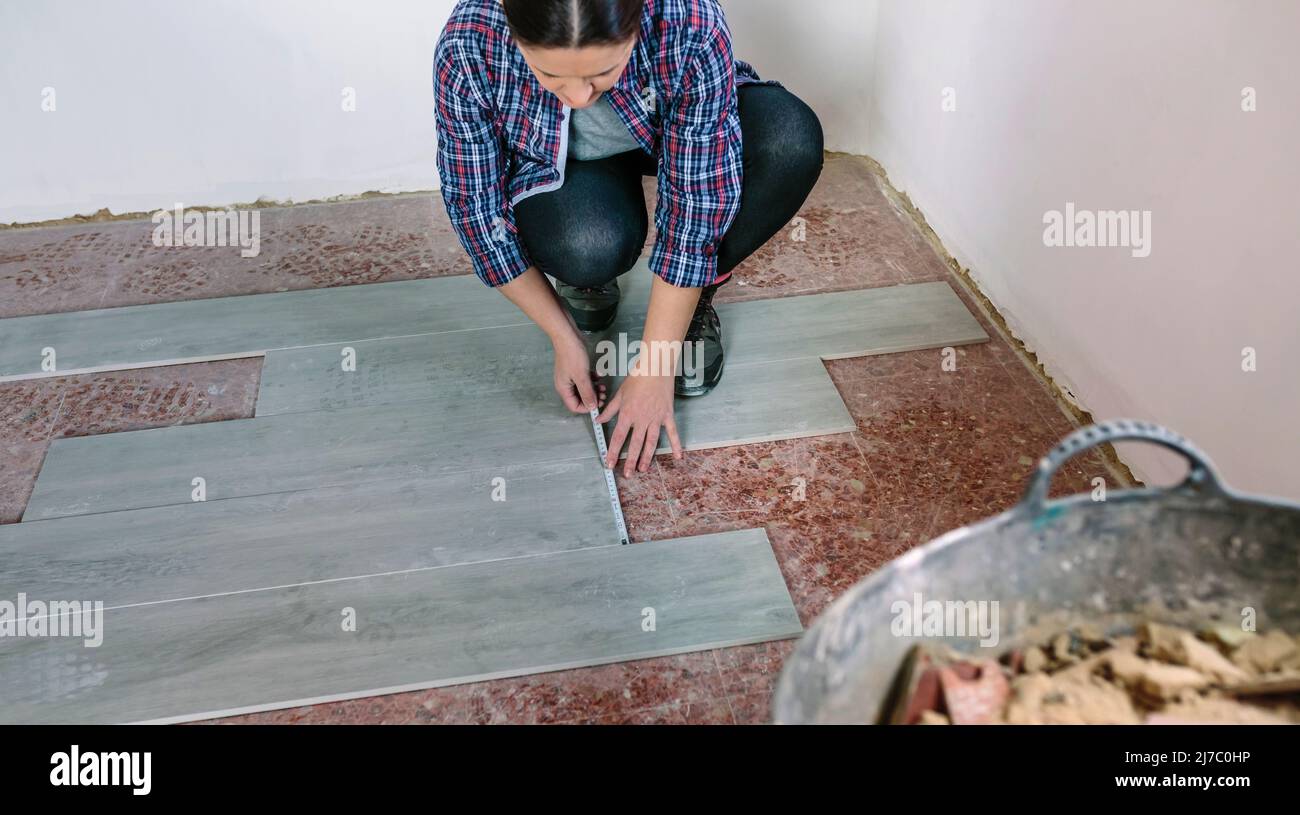 Mattonelle di misurazione muratore femmina per installare un pavimento Foto Stock