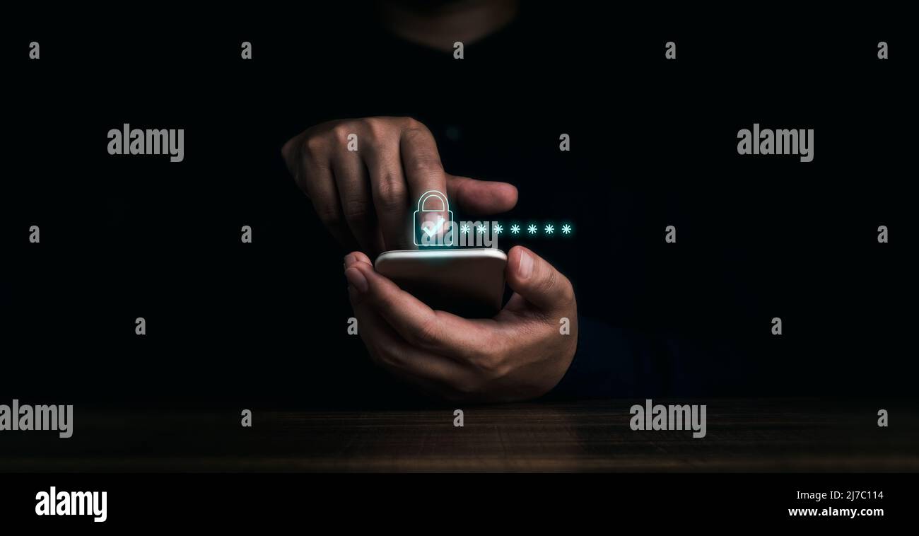 Le icone di blocco e la password nascoste dietro gli asterischi appaiono mentre il dito dell'uomo tocca il telefono cellulare su sfondo scuro. Sicurezza informatica, protezione dei dati Foto Stock
