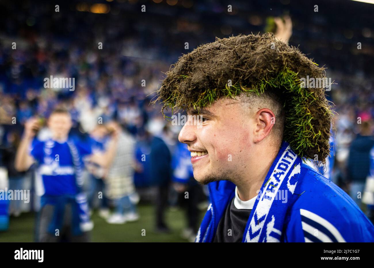 Fan di Schalker feiern den Aufstieg - ein cappello del ventilatore ein Stück Rasen auf dem Kopf FC Schalke 04 - St. Pauli 07.05.2022, Fussball; Saison 2021/22 Foto: Mor Foto Stock