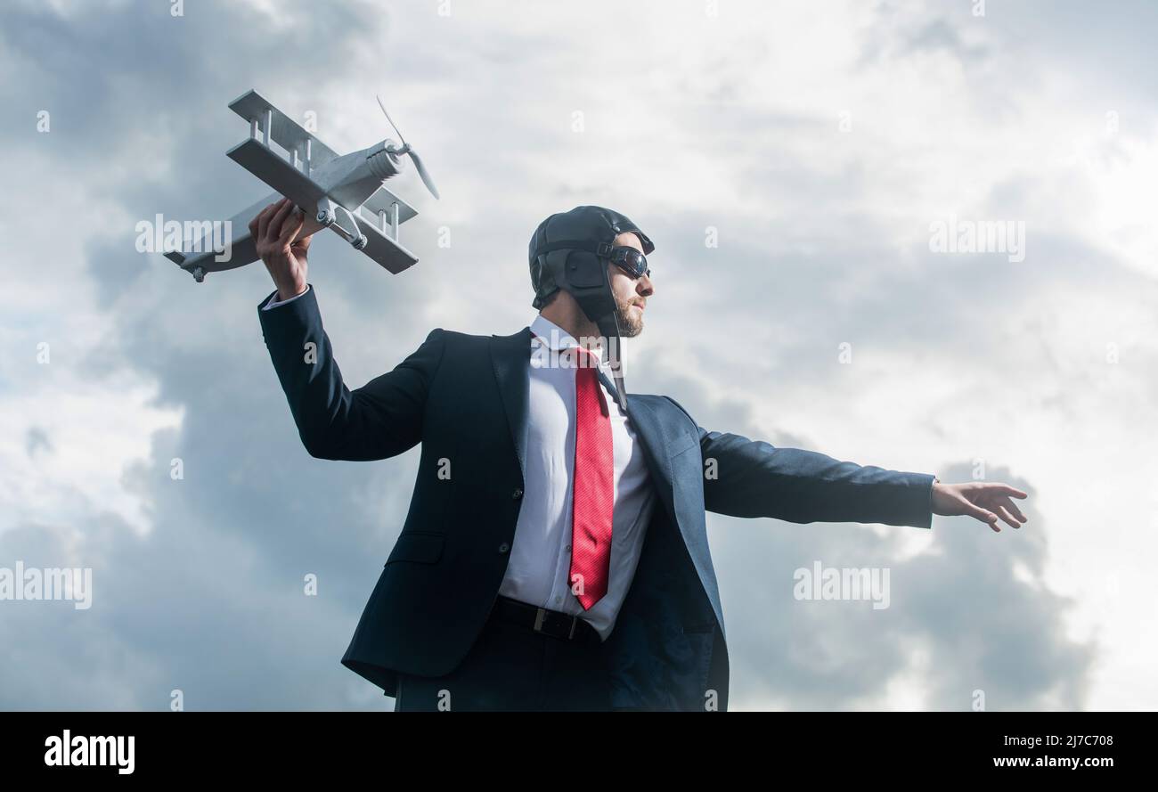 uomo d'affari in abito e cappello pilota lancia giocattolo aereo. concetto di progresso Foto Stock