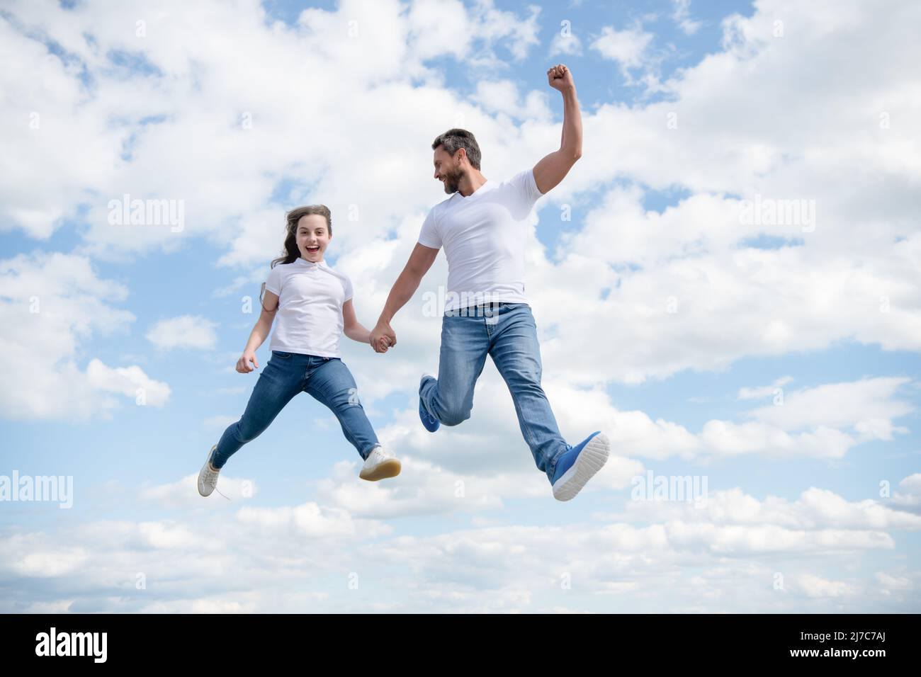 felice padre e figlia saltano in cielo Foto Stock