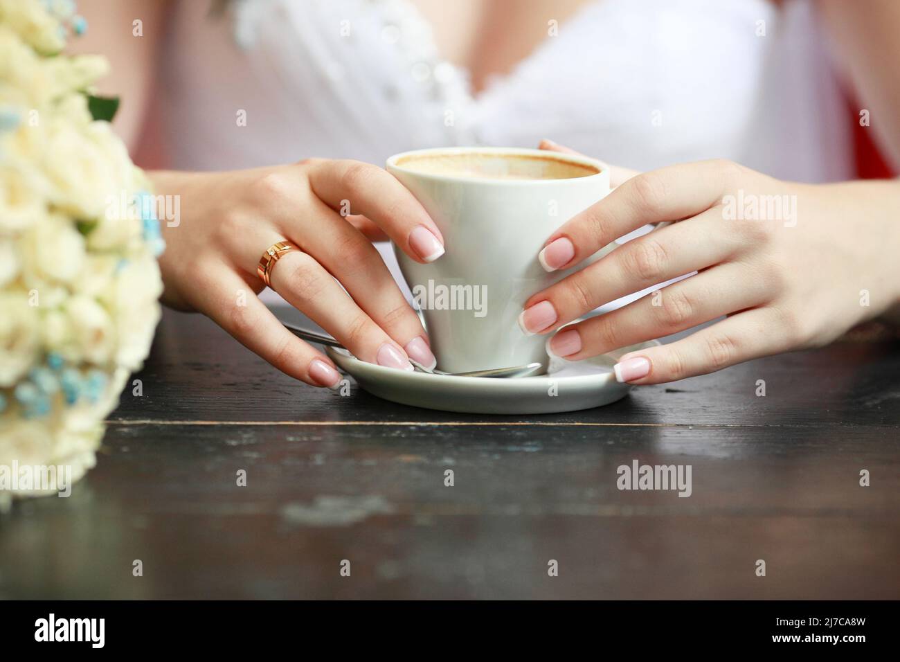 Le mani di sposa con una tazza di caffè Foto Stock