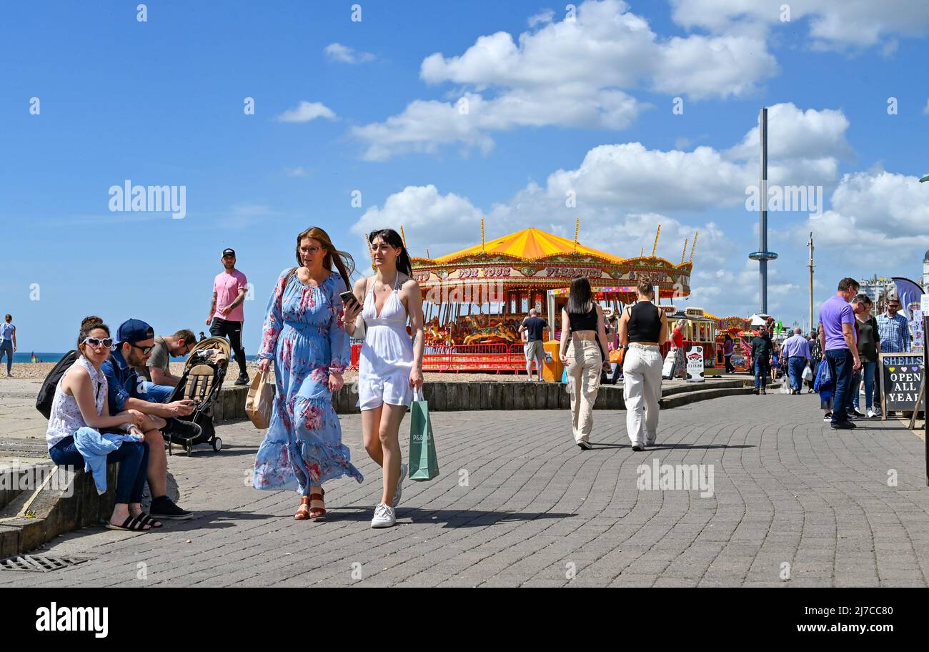 Brighton UK 8th May 2022 - i visitatori godono di una calda giornata di sole sulla spiaggia di Brighton e sul lungomare, come si prevede che le temperature raggiungano oltre 20 gradi in alcune parti del Regno Unito: Credit Simon Dack / Alamy Live News Foto Stock