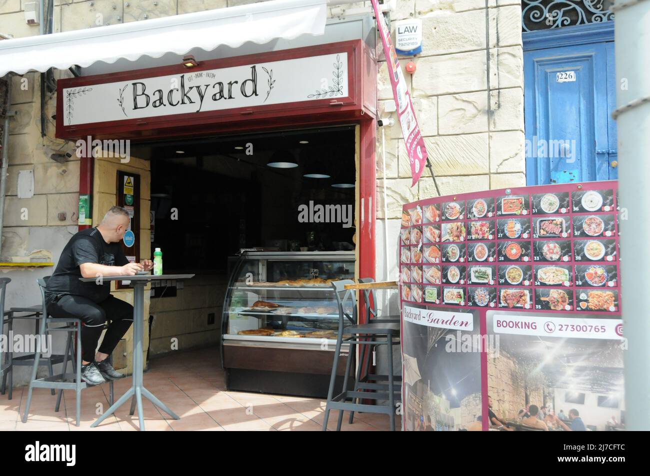 (220508) -- VALLETTA, 8 maggio 2022 (Xinhua) -- un uomo siede di fronte ad uno snack bar che vende torte a Msida, Malta, il 29 aprile 2022. PER ANDARE CON 'caratteristica: Il sussidio del pane fornisce l'ancora di salvezza tra i prezzi alimentari in aumento a Malta' (Xinhua/Chen Wenxian) Foto Stock