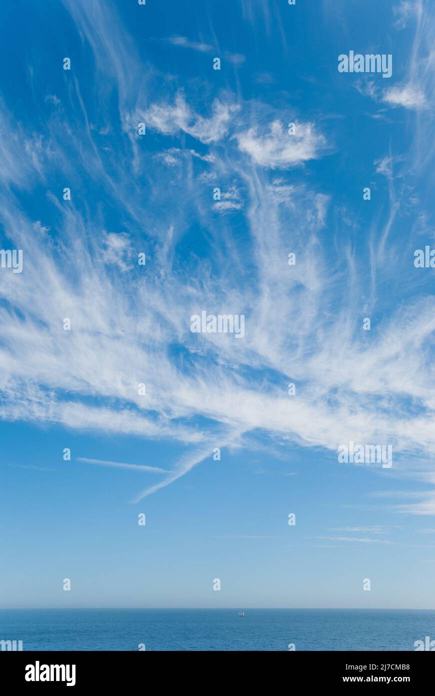 Regno Unito, South Devon Coast. Il canale inglese. Un ampio spazio vuoto di alte nuvole di ghiaccio di cirro, cielo blu e orizzonte marino. Foto Stock