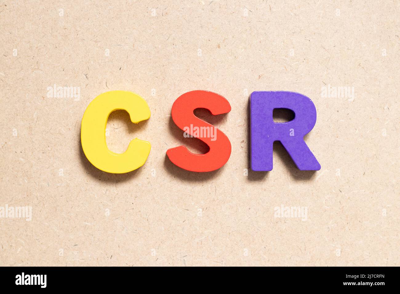 Lettera alfabetica a colori in parola CSR (abbreviazione di responsabilità sociale d'impresa) su sfondo di legno Foto Stock