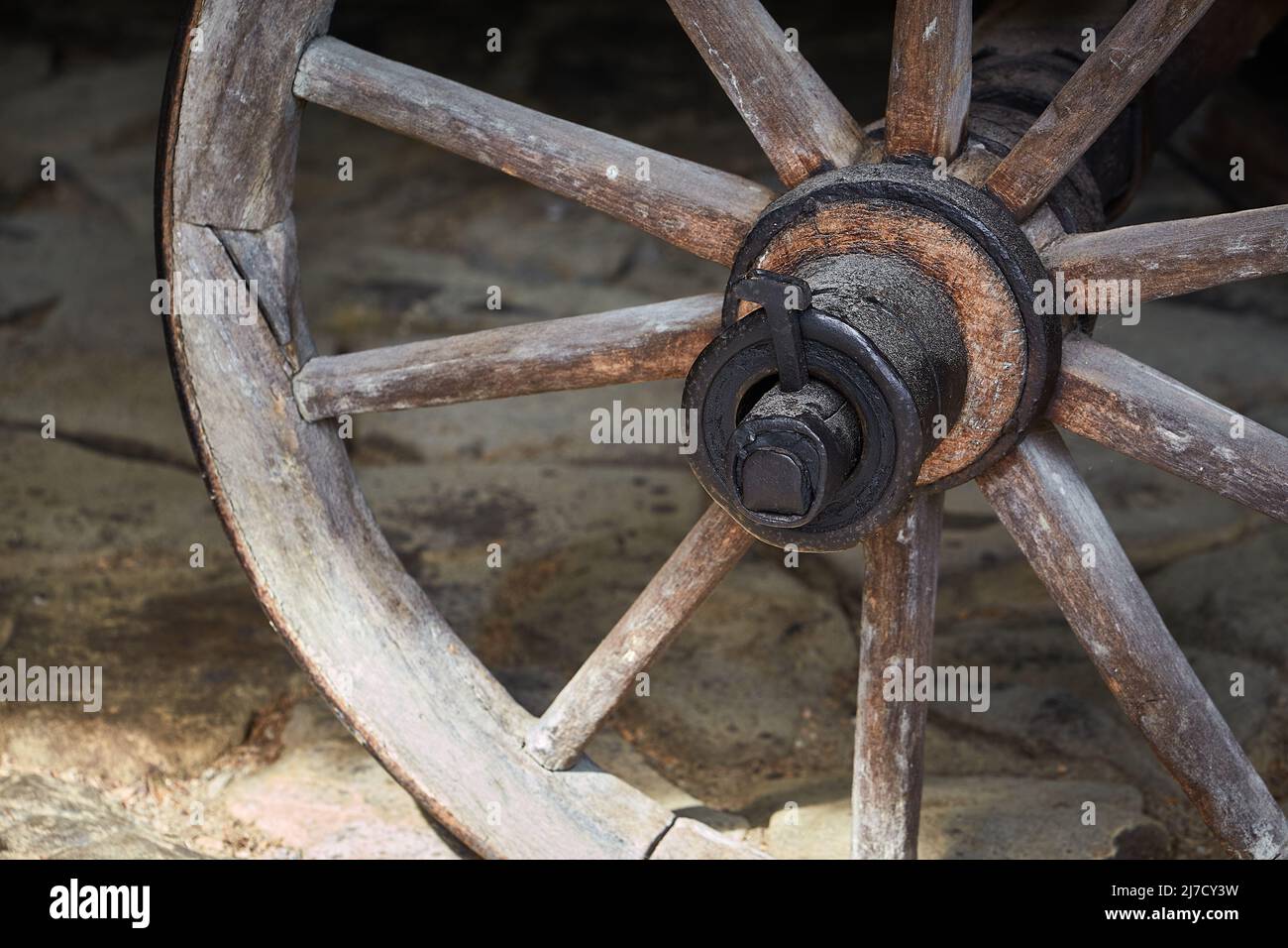 Primo piano di una vecchia ruota di legno su un rustico carro di legno Foto Stock