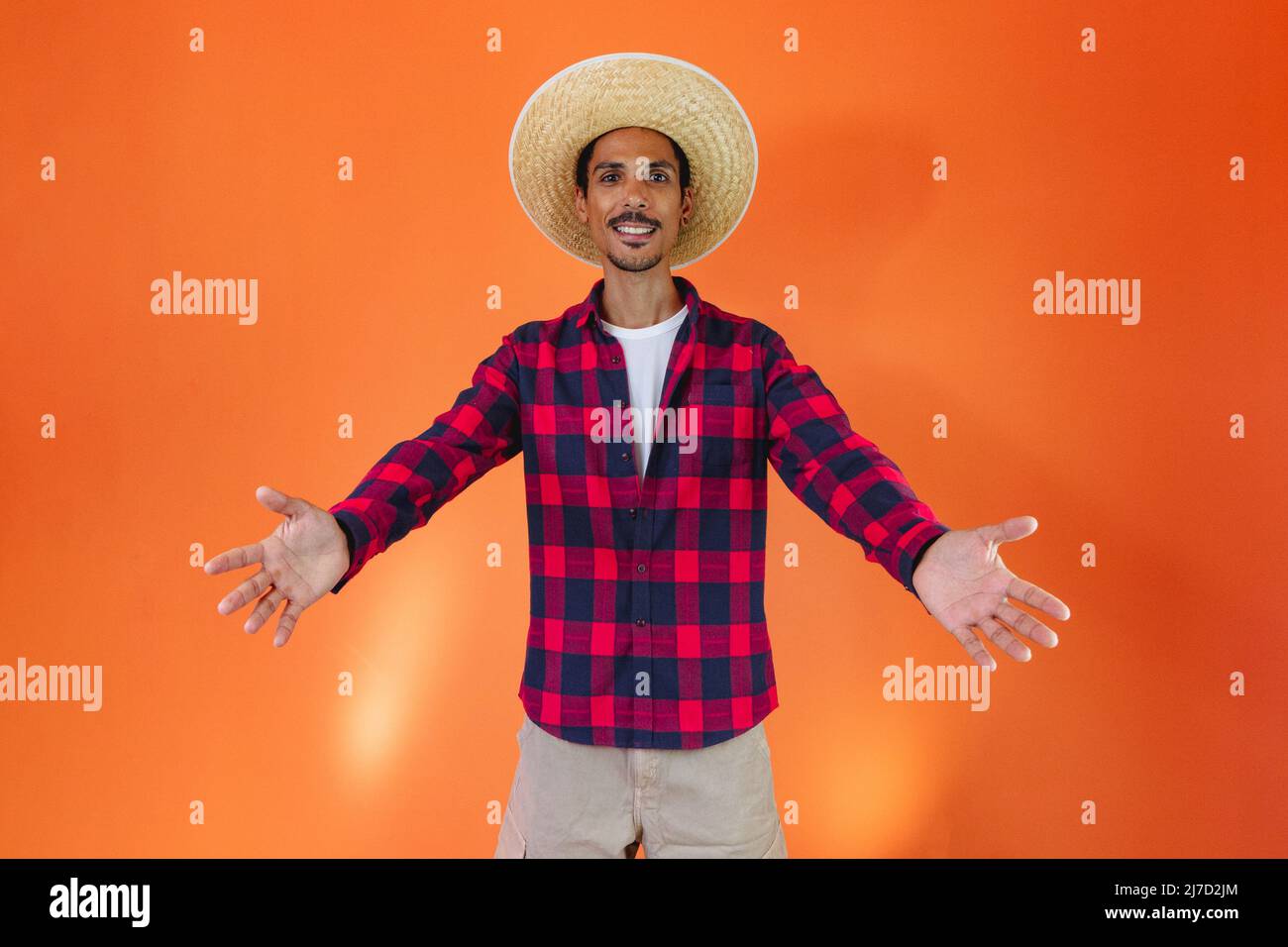 Uomo nero che indossa abiti tradizionali per Festa Junina isolato su sfondo arancione Foto Stock