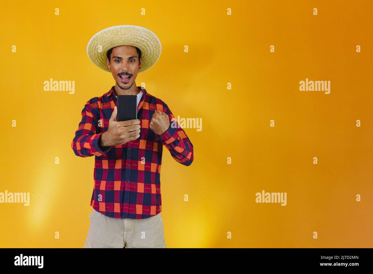 Uomo nero che indossa abiti tradizionali per Festa Junina isolato su sfondo giallo Foto Stock