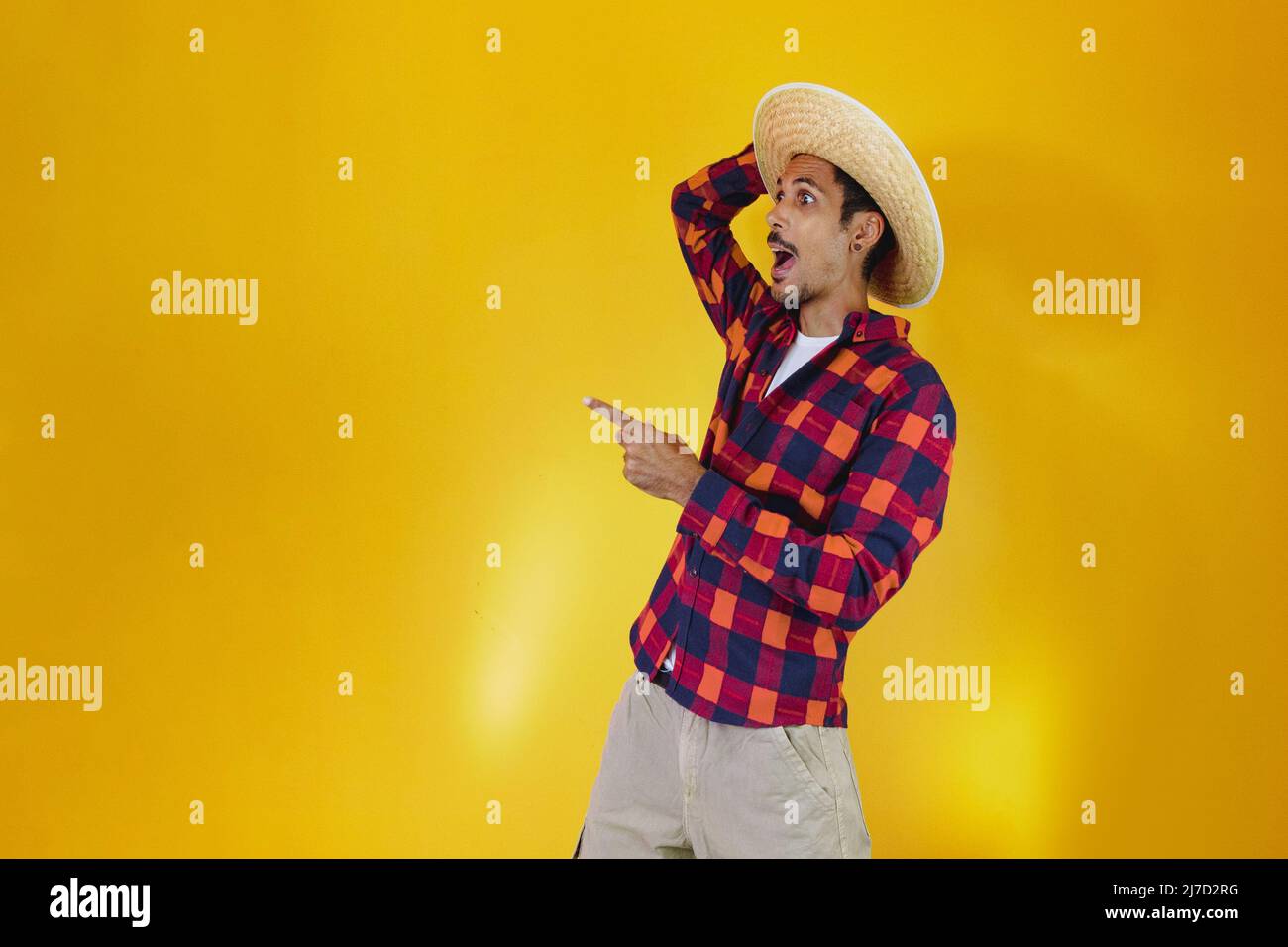Uomo nero che indossa abiti tradizionali per Festa Junina isolato su sfondo giallo Foto Stock