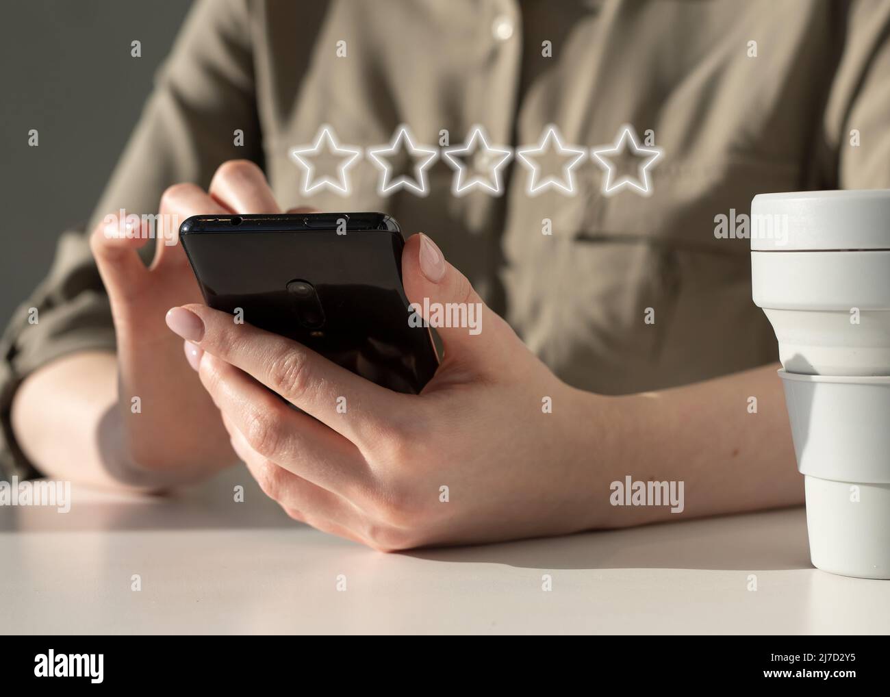 Donna che utilizza il telefono per la valutazione del servizio, l'applicazione per smartphone o la qualità del prodotto. Feedback sulla soddisfazione dei clienti online. Foto di alta qualità Foto Stock
