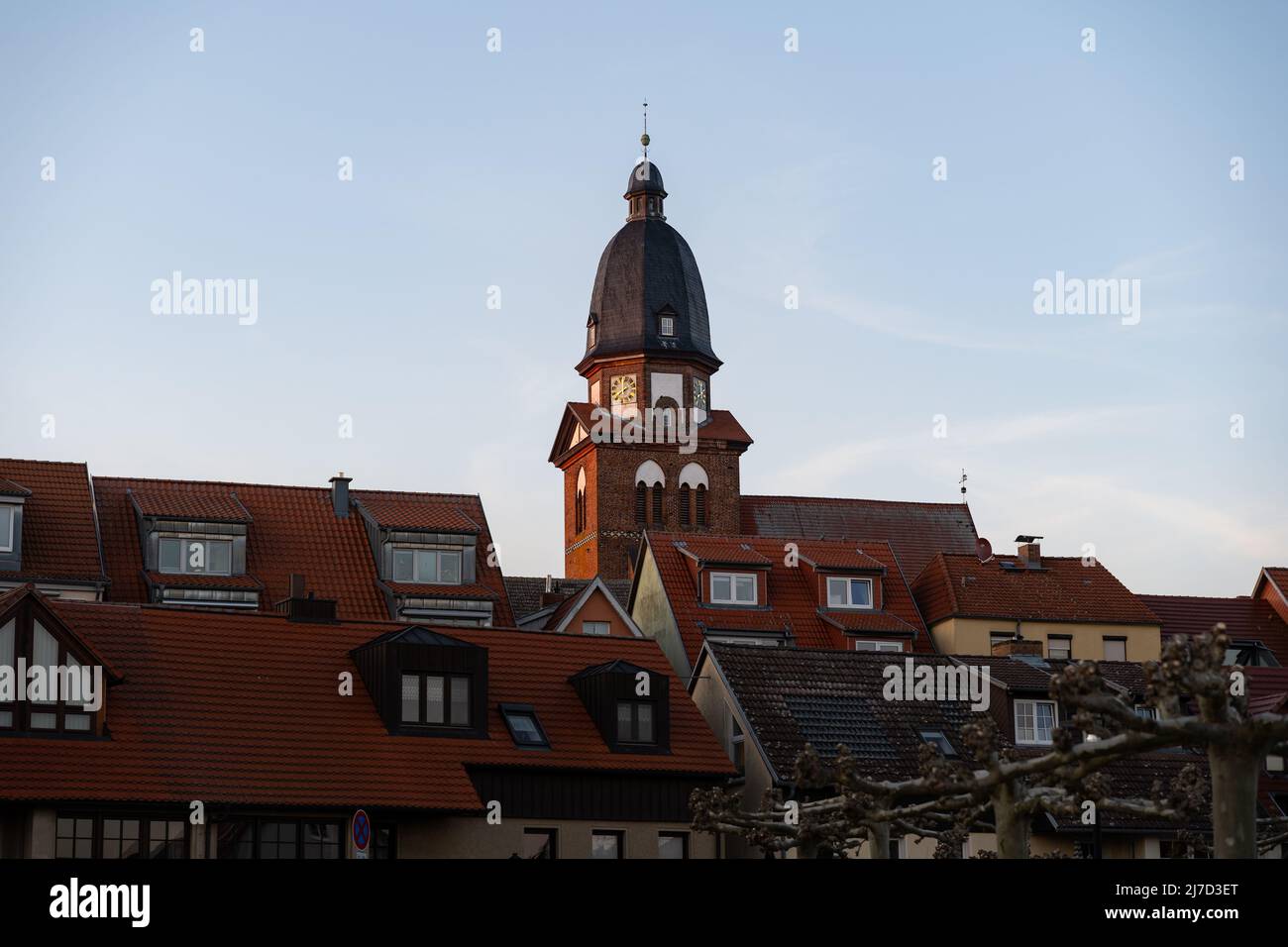 Grande chiesa nello skyline di Waren (Müritz) in Germania. Vecchi edifici in città con tetti di tegole rosse. Architettura tradizionale di sera. Foto Stock