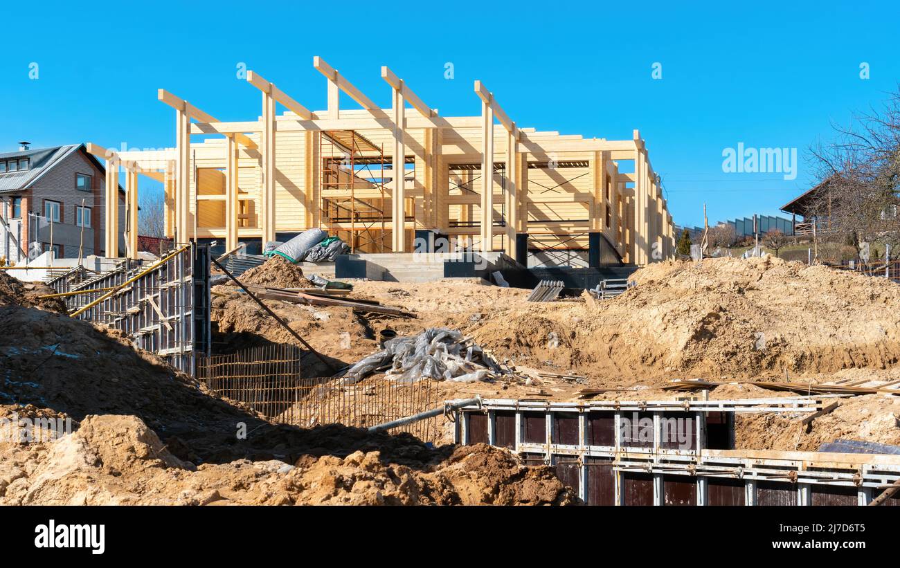 Cantiere di una casa in legno in legno a doppio profilo. L'uso della cassaforma quando si concretizza la fondazione della recinzione. Costruire sabbia e. Foto Stock