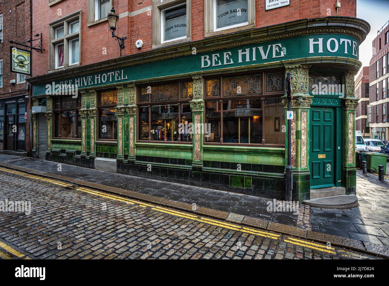 L'esterno della casa pubblica del Beehive Hotel si trova di fronte a piastrelle smaltate verdi e gialle. High Bridge , Newcastle upon Tyne, Inghilterra. Foto Stock