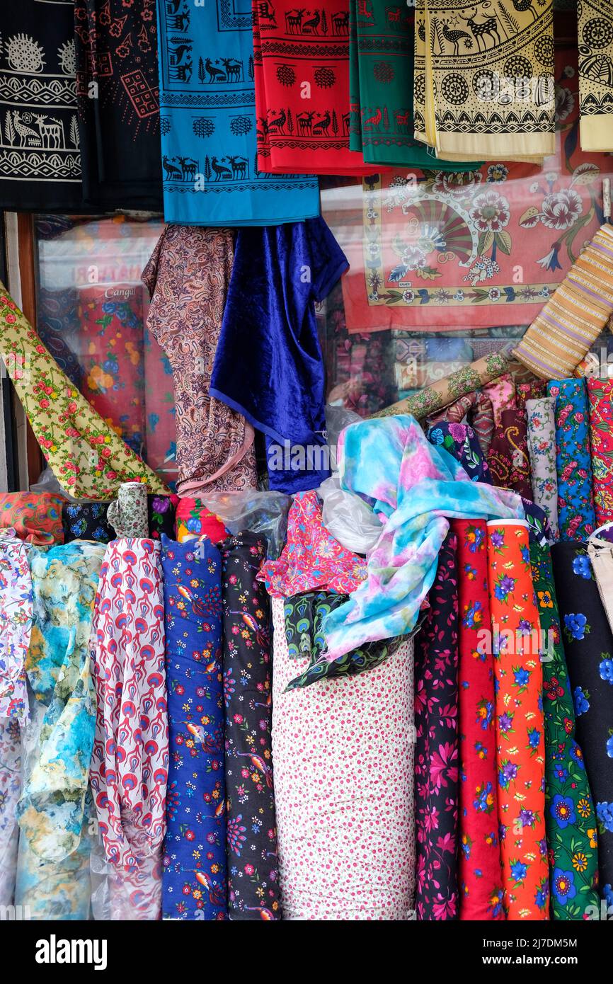 rotoli di tessuto colorato pronti per la vendita davanti a un negozio. Foto Stock