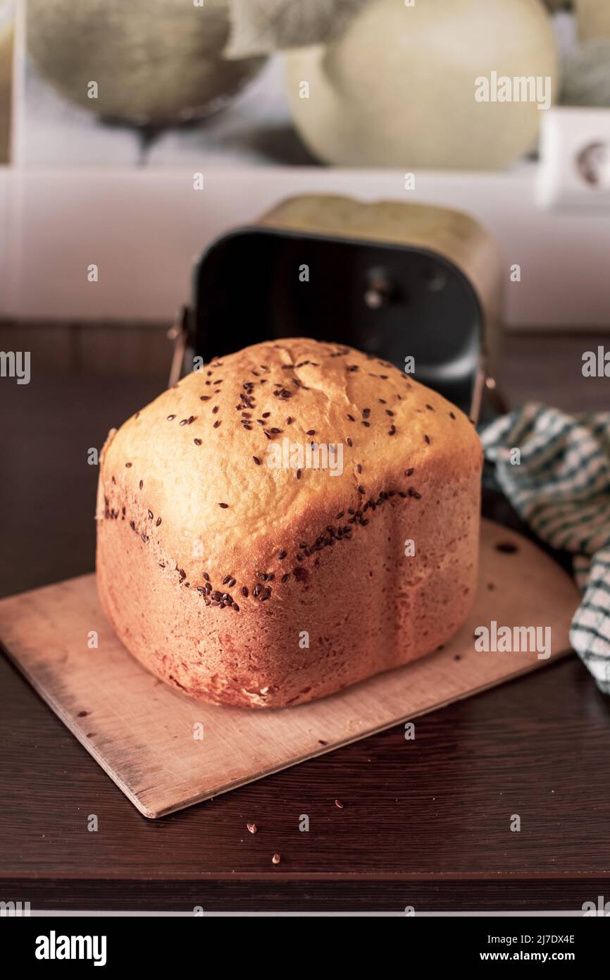 Pane appena sfornato dalla macchina del pane sul tavolo da cucina. Cottura fatta in casa. Foto Stock