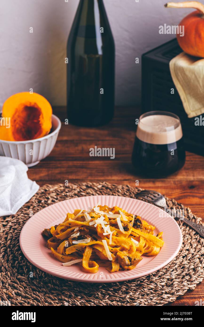 Pasta fettuccina con salsa di zucca e funghi guarniti con parmigiano grattugiato Foto Stock