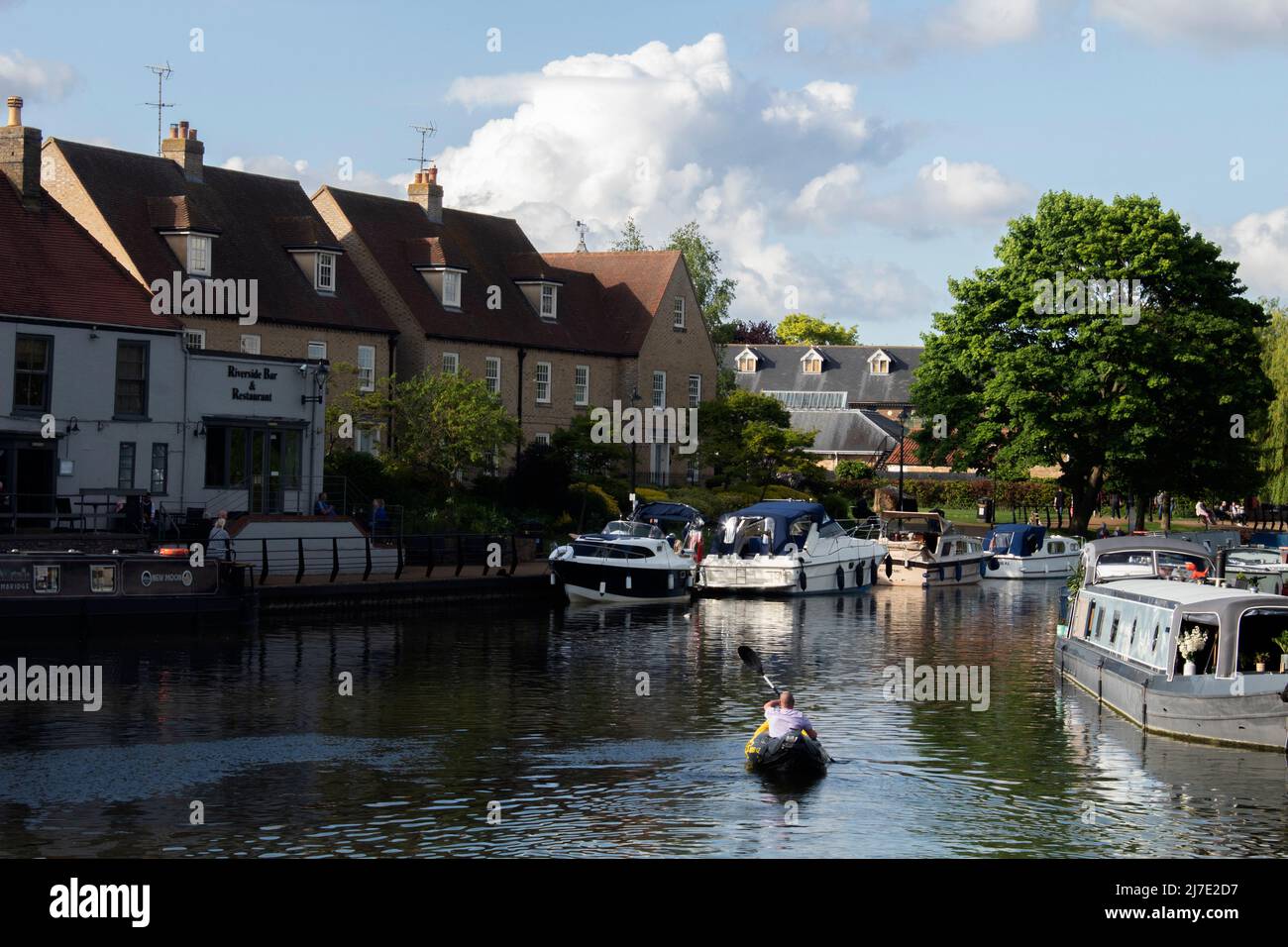 Kayak lungo il fiume Great Ouse, oltre a pub e barche, Ely, Cambridgeshire, Regno Unito Foto Stock