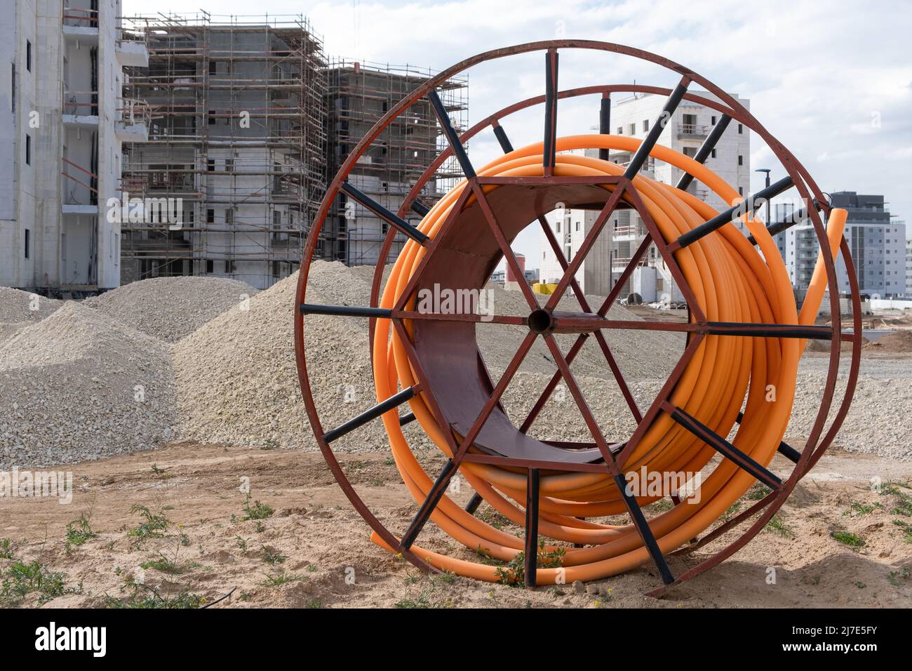 Proteggere i cavi negli impianti elettrici, sviluppo delle comunicazioni, bobine grandi di tubo PVC arancione tubo in plastica tubo pvc su costruzione si Foto Stock