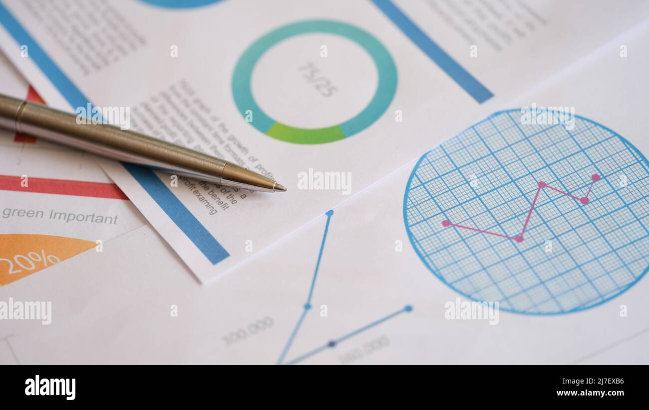 Grafici analitici finanziari di marketing con penna su tabella Foto Stock